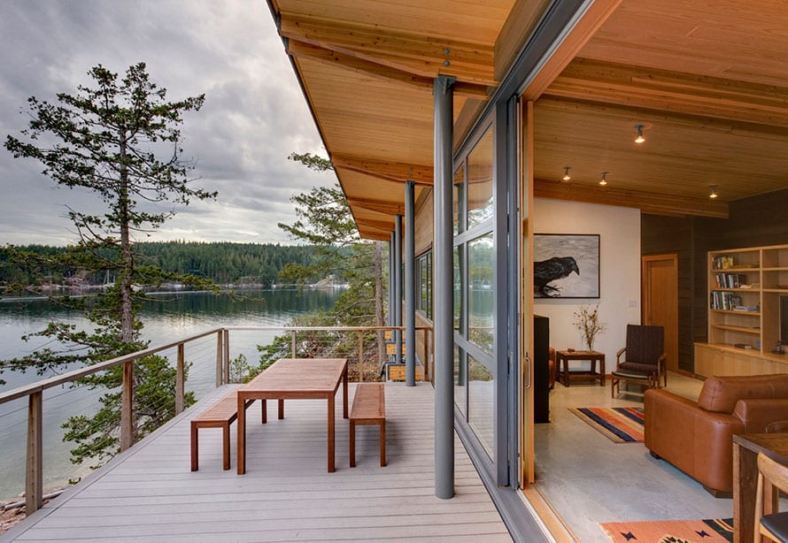 Wood clad lift and slide doors by the sea