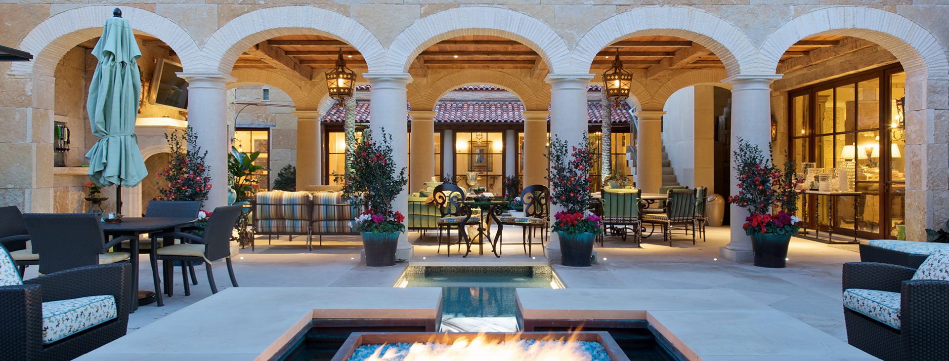 A Texan residence with fire table and arched columns and traditional wood windows