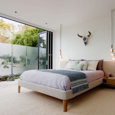 Wood bifold doors open bedroom to outdoors