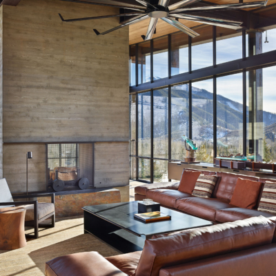 Massive fireplace, couches and steel residential storefront windows in background