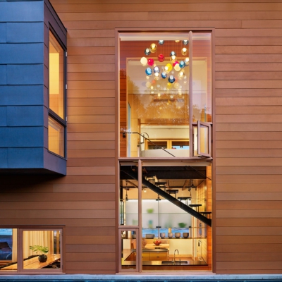 Slim wood storefront window spans levels overlooking the pool