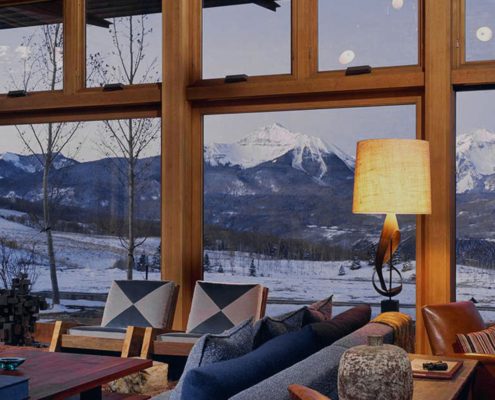 Looking through large custom wooden windows to reveal a beautiful mountain landscape.