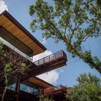 cantilevered catwalk and rows of modern window walls viewed from below