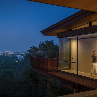 woman walking along lighted enclosed catwalk overlooking Austin