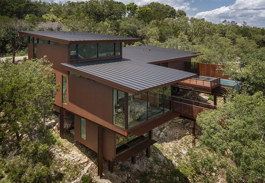 Modern mountain home with residential storefront windows perched on a cliff